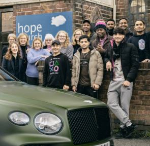 People stood around a Bentley car,